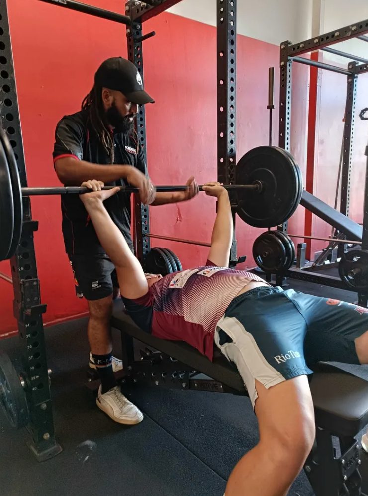 Coach Zac spotting a loaded bench press